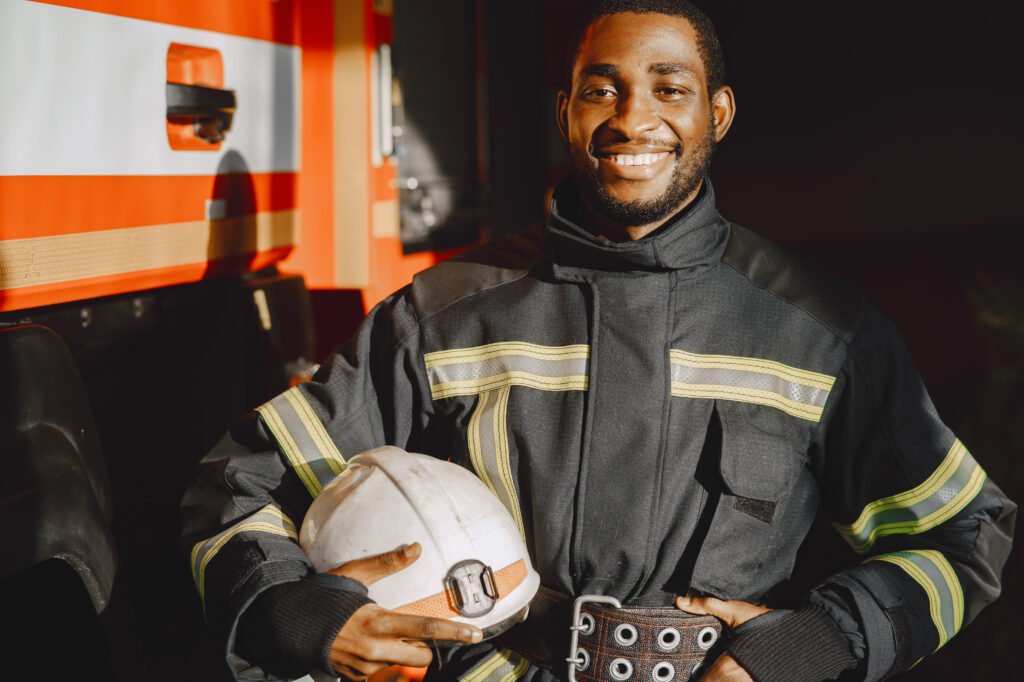 portrait of a firefighter standing in front of a fire engine